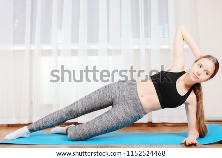 Young girl is sporting gymnastic mate. Concept home training.