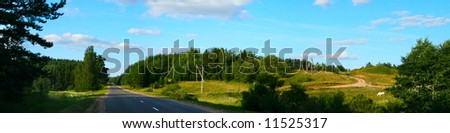 Beautiful panoramic landscape with the dark blue, cloudy, solar sky and road