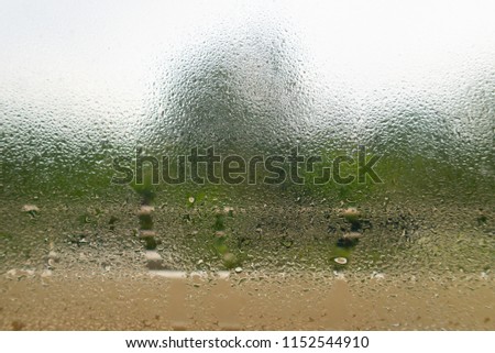 Blurry waterdrops on glass surface with selective focus