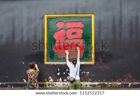 Baoguang Temple,in xindu ,Sichuan,China - August 5, 2018   .Visitors touch the word "Fu" in the temple to pray for blessing  in Baoguang Temple