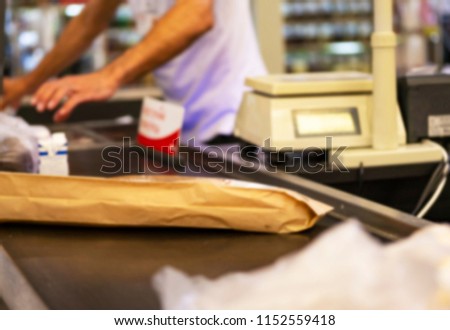 The cashier carries out products through cash desk. The worker on cash desk in shop.  cashier with customer paying grocery products.  soft blurry photo. 