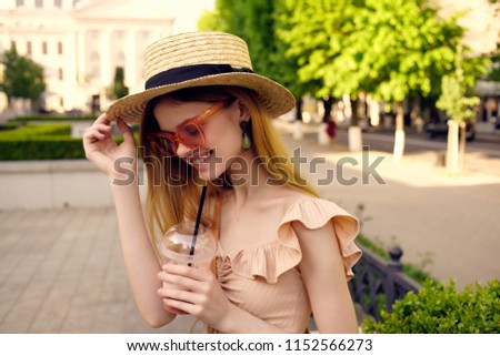 happy woman in Straw hat holds a drink in hand, green park                               