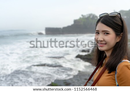 Traveler photography girl with dslr camera take photo with Bali beach at background. Young lady professional photographer. Asian hipster female traveling concept.