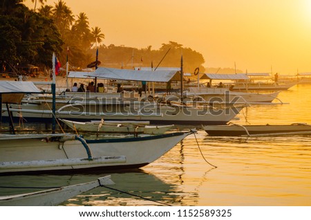Sunset on the beach with silhouette of banca boat at Panglao Island, Bohol, Philippines