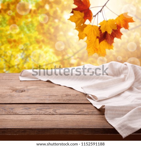 Empty wooden table with tablecloth. Napkin close up top view mock up for design. Autumn rustic background.