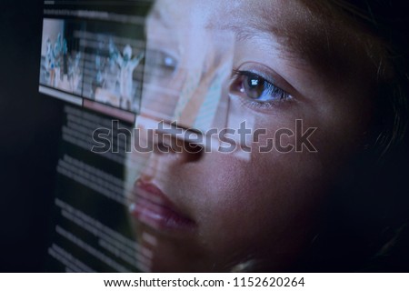 Close up of a little girl (kid) looking at some futuristic holograms. Concept: Technology, future, graphics