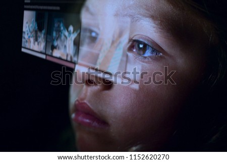 Close up of a little girl (kid) looking at some futuristic holograms. Concept: Technology, future, graphics