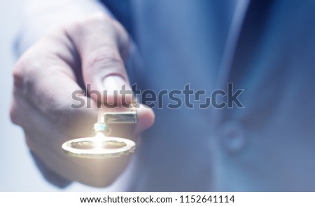Businessman gives the golden key in his hand, the key of success in business