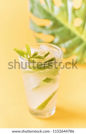 refreshing lemonade on a yellow background, a sheet of monstera, a advertising concept


