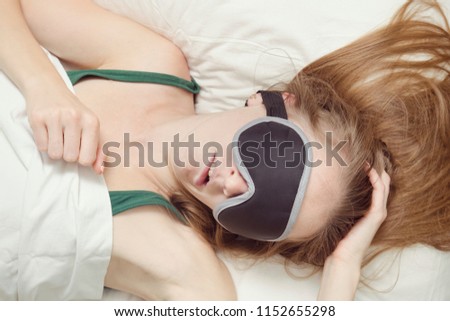 Young woman is sleeping in a mask for sleep. Relaxation
