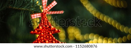 Red ball hanging on a green christmas tree branch isolated on white background, very shallow, the format of the banner, wide long