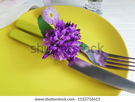 plate, fork, knife, chrysanthemum flowers on a white wooden background