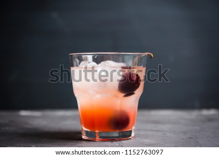 Old fashioned cocktail with cherry. Selective focus.