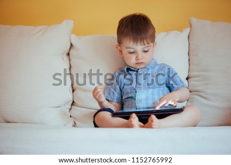 depressed baby boy bored of playing with technology