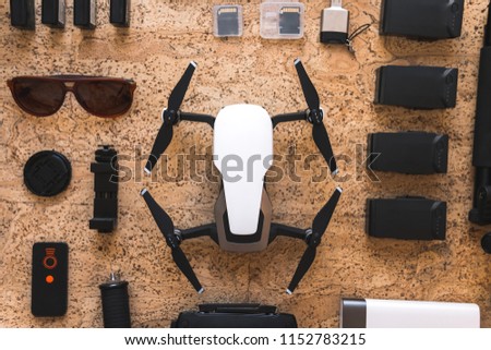 top view of work space videographer, blogger, movie maker with drone, three-axis stabilizer, cleaning kit, memory card, power bank, USB card reader, lens camera accessory on wooden background