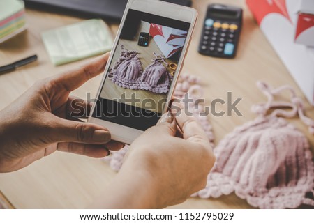 woman hand taking picture of her handmade product by smart phone for selling online 