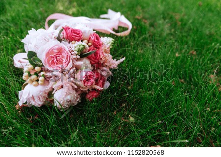 Wedding bouquet of roses on green fresh grass