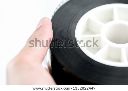 Male Hand Holding 35mm Movie Film Reel, Motion Picture Film Isolated On White Background.