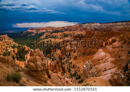 Summer thunderstorm looms over Sunrise Point in Bryce Canyon National Park.  The colors and majesty of the canyon are enhanced with the moody skies and distant rain clouds.