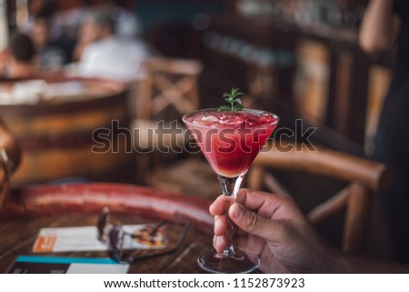 Man holding cocktail and in hand. Blurry background and happy summer.