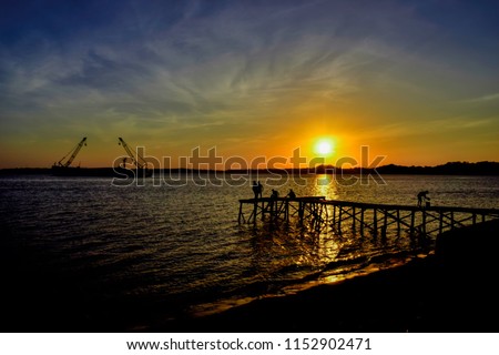 enjoy the sunset on the dock with fishermen while fishing