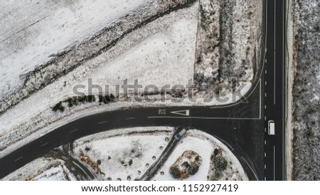 Aerial view of snowy fields and road. Winter forest and the road. View from above. The photo was taken with a drone. Pine and fir forest in the snow at New Zealand.
