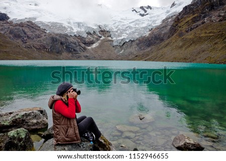 Woman takes a picture on the lake