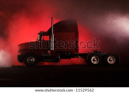 A red 18 wheeler semi tractor trailer truck with chrome exhaust pipes, lug wheels, and gray smoke.