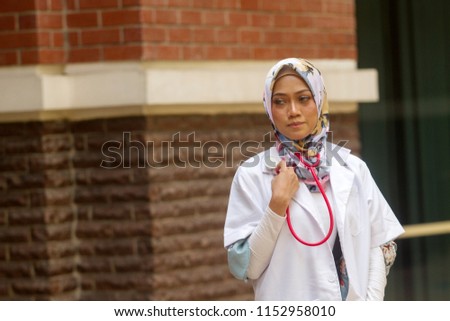Asian medical staff in Hijab or Head Scarf smiling with sunlight background