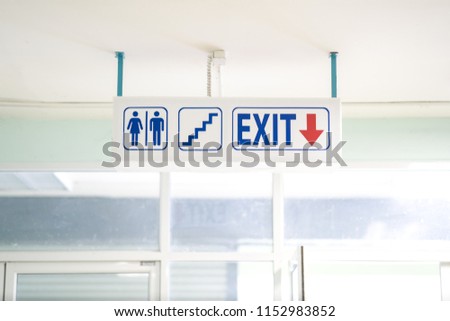 Sign toilet, stair and exit direction, blue text and red arrow on white background sign. It show for information transpot interior building for emergency to safety.