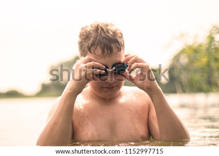 a boy with blond hair wears glasses for swimming