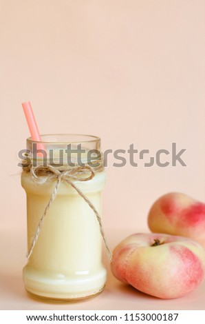 Homemade peach yogurt on pastel pink background. Close up