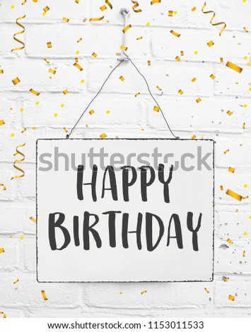 Happy birthday text. Banner on white brick background with golden party confetti. Celebrate date of birth.