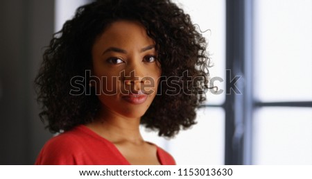 Young black lady deep in thought turning to face camera in indoor setting Royalty-Free Stock Photo #1153013630