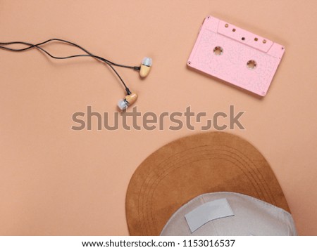 Cap, audio casset earphones on a brown background, music lover, minimalism, top view

