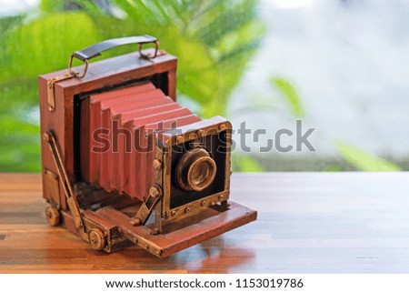 Red Vintage film camera - Folding Pocket camera, vintage accessories on wooden table.