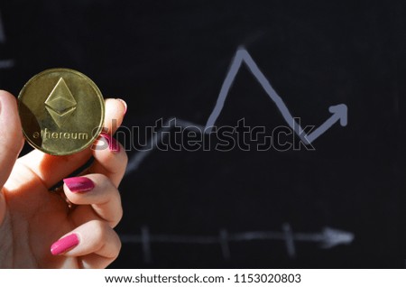 Ethereum. Crypto currency Ethereum, ETH. Ethereum golden coin. Blockchain technology, mining concept. coin of crypto currency. electronic money. female hand holds a coin on a background of a graphic