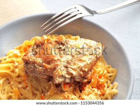 Noodles with rabbit stewed with carrots and onions in sour cream