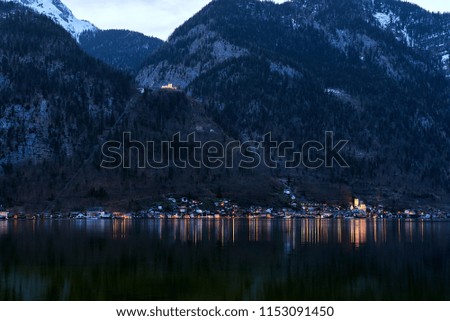 Unique view of famous Hallstatt mountain village in the Austrian Alps at night. Beautiful view on the other side of the shore. Salzkammergut region, Hallstatt, Austria. Neutral colors. 