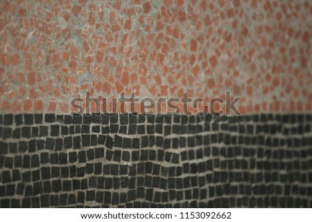 Close up indoor view of an ancient floor made of red and black mosaics. Pattern of small ceramic squares. Old surface divided in two colors. Abstract design with lines and angles. Vintage picture.