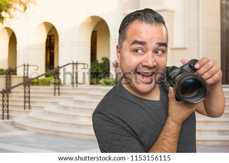 Hispanic Young Male Photographer With DSLR Camera Outdoors.