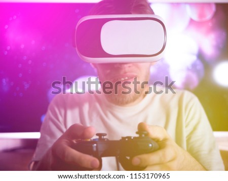 close up happy emotion person playing video games with controller on abstract background toned with virtual glasses