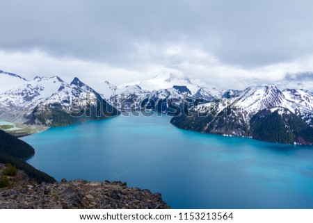 Panoramic view of the Blue Lake Garibaldi with the snow capped mountains in the background