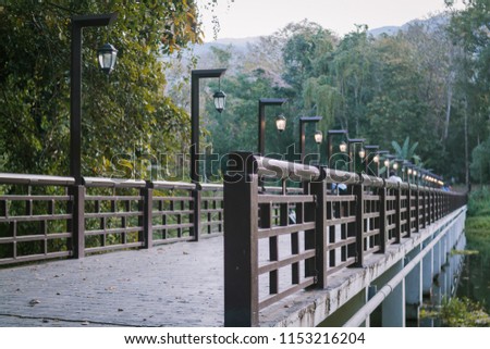 Light and dark images in the evening,Street lights are installed on the bridge railings in the park to provide light in the evenings and early morning for people who exercise and relax.