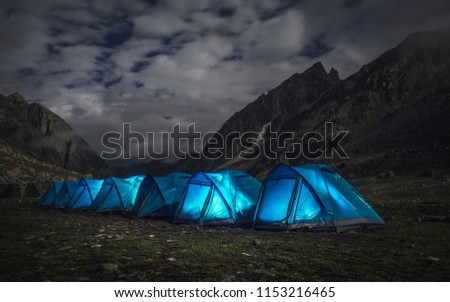 glowing camping tents in the night and the cloudy sky in Manali,India