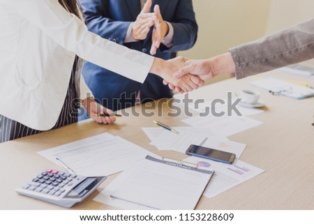 Estate agent shaking hands with his customer after contract signature (Happy Group of business people joining hands)