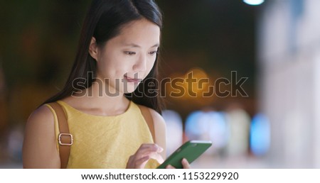 Woman use of mobile phone in city of Shenzhen at night