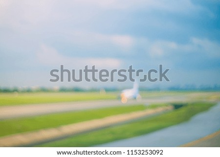 Blur taxi way of airplane to boarding and landing with blue sky and green field