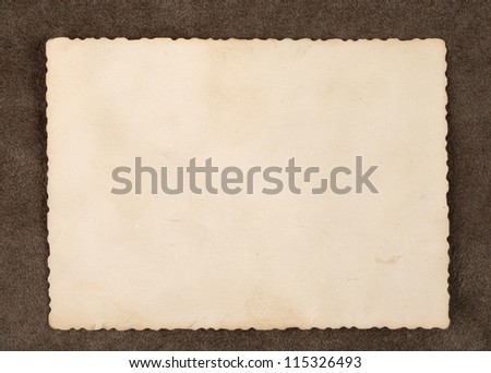 Reverse side of an old photo print with a decorative border on brown background