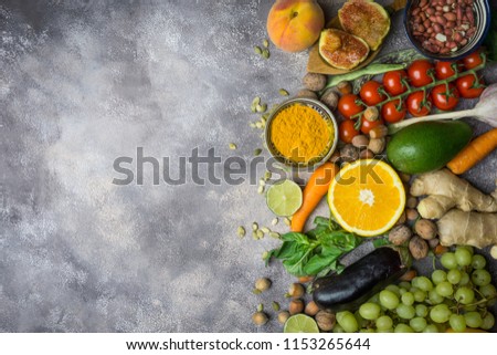 Clean food selection. Healthy food background, frame of organic food. Vegetables, fruits, nuts, spices. Balanced diet on a dark black background. Top view. Copy space left.